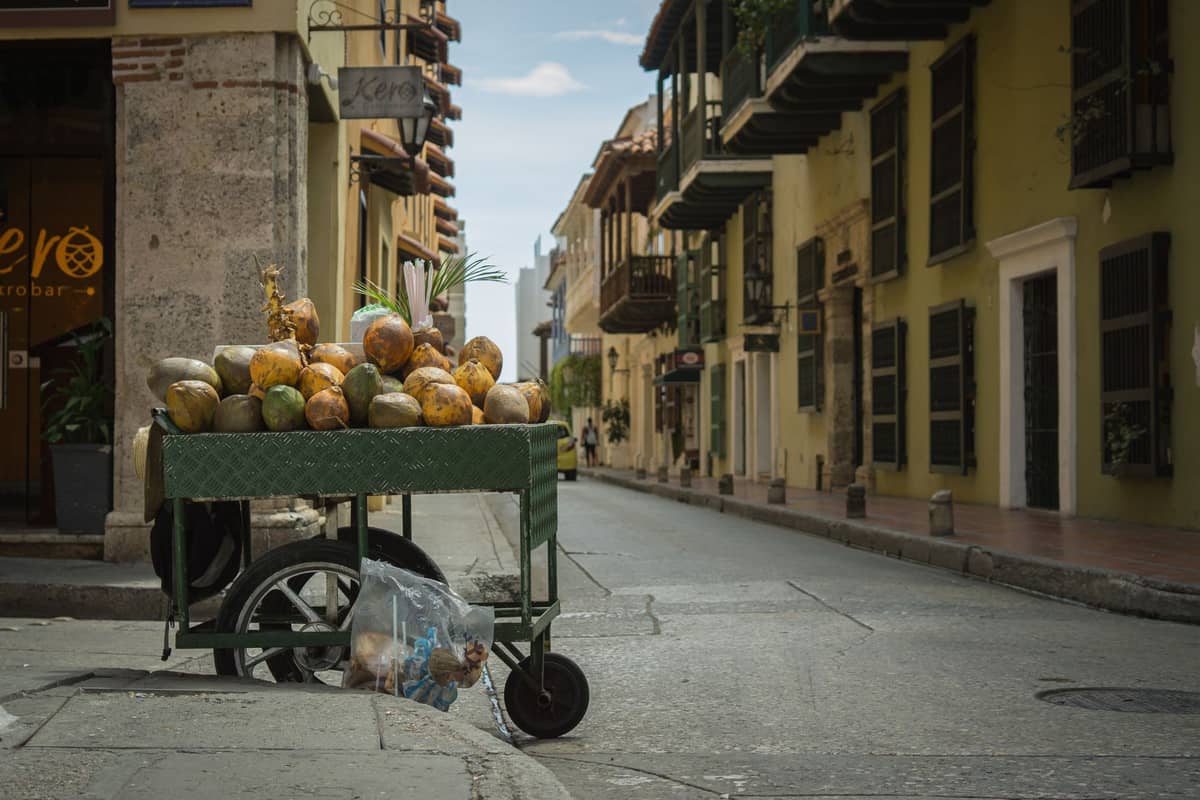 Street vendor cart filled with coconuts on a quiet street in Cartagena’s historic district.