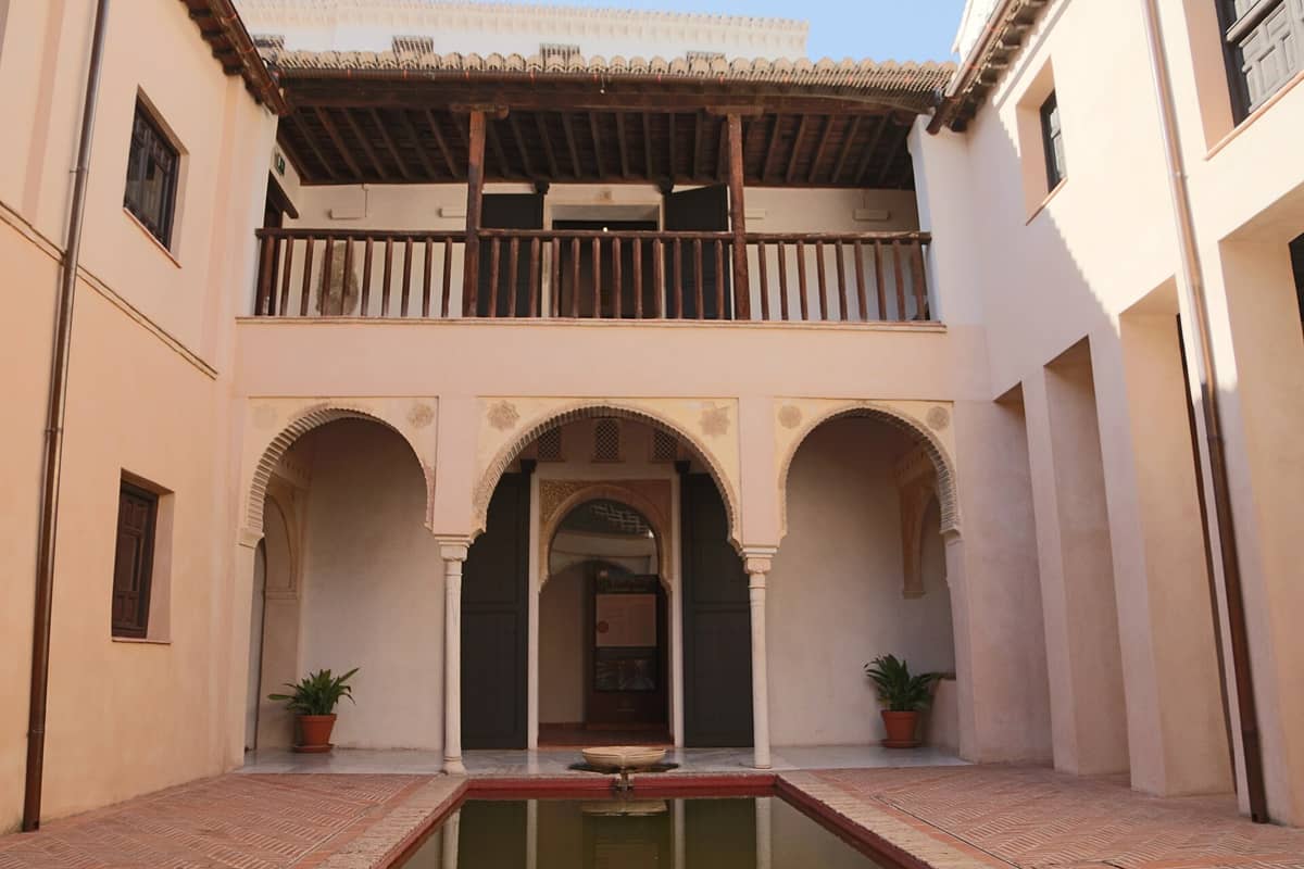 ลานกลางบ้าน Casa de Zafra เมืองกรานาดา เห็นซุ้มประตู Nasrid ระเบียงไม้ ฉาบปูนปั้น และสระน้ำทรงสี่เหลี่ยมเล็กตรงกลาง