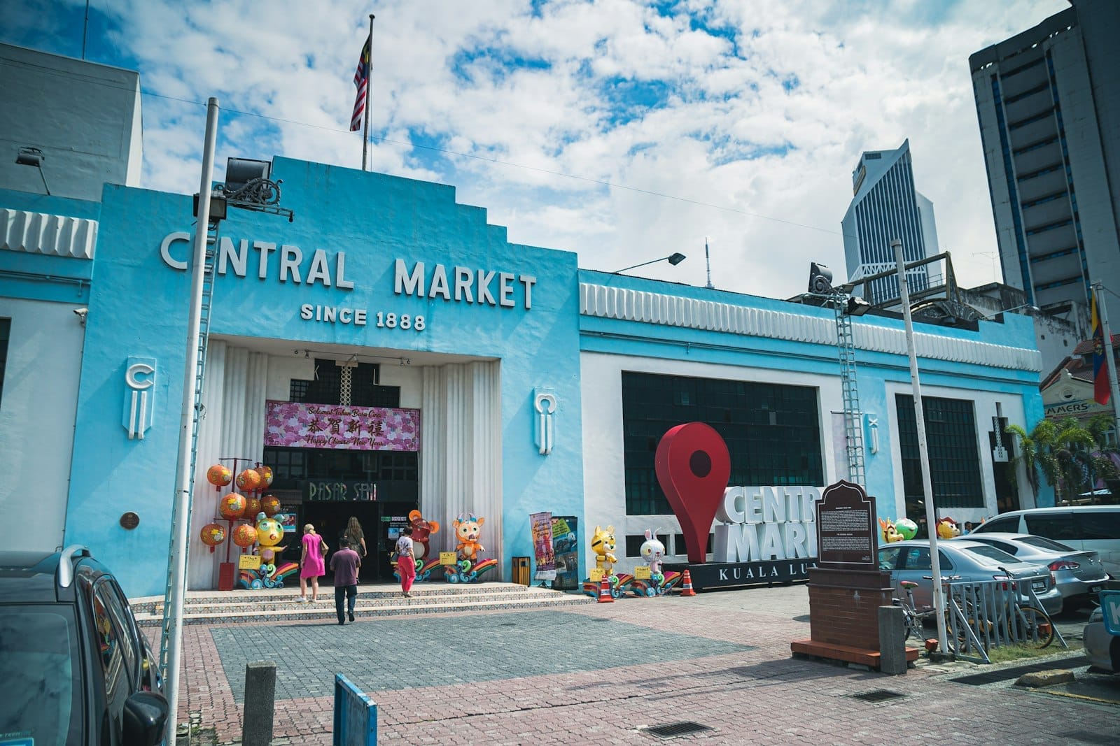 Central Market Kuala Lumpur exterior with blue Art Deco facade, entrance sign and visitors at Pasar Seni heritage market
