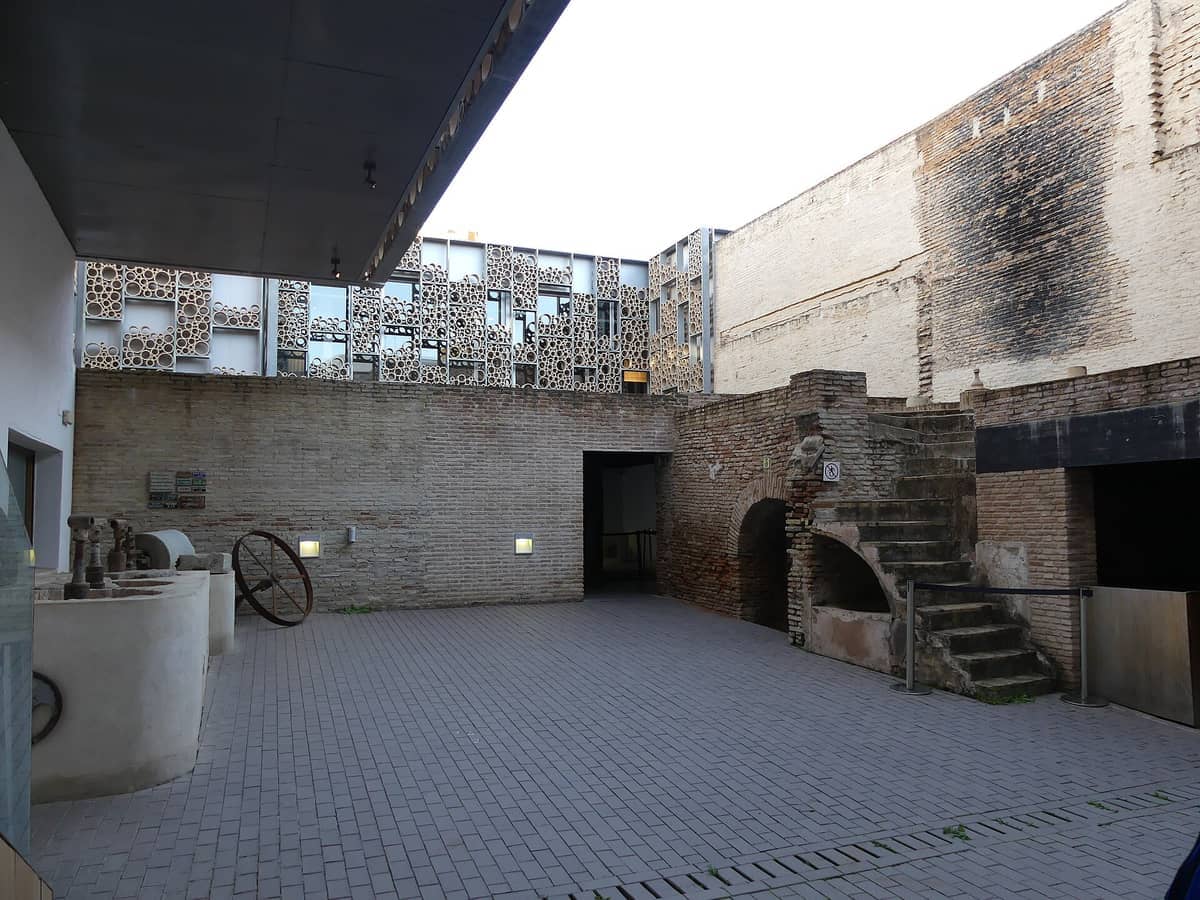 ลานภายในของ Centro Cerámica Triana โดดเด่นด้วยเตาเผาอิฐเก่าแก่ บันไดหินทางประวัติศาสตร์ เครื่องมืออุตสาหกรรม และด้านหน้าอาคารสมัยใหม่อันโดดเด่นพร้อมลวดลายวงกลม