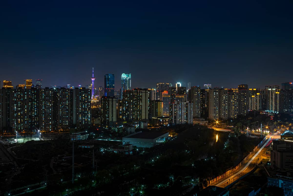 Nächtliche Skyline von Chengdu mit beleuchteten Gebäuden, hohen Türmen und einem dunkelblauem Himmel, die die Stadt zeigt, die nach Einbruch der Dunkelheit zum Leben erwacht.