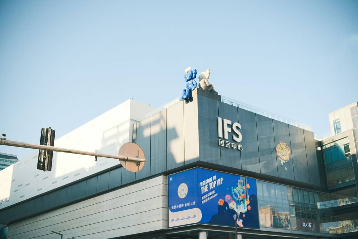 Esterno del centro commerciale Chengdu IFS con una grande scultura sul tetto sotto un cielo sereno.
