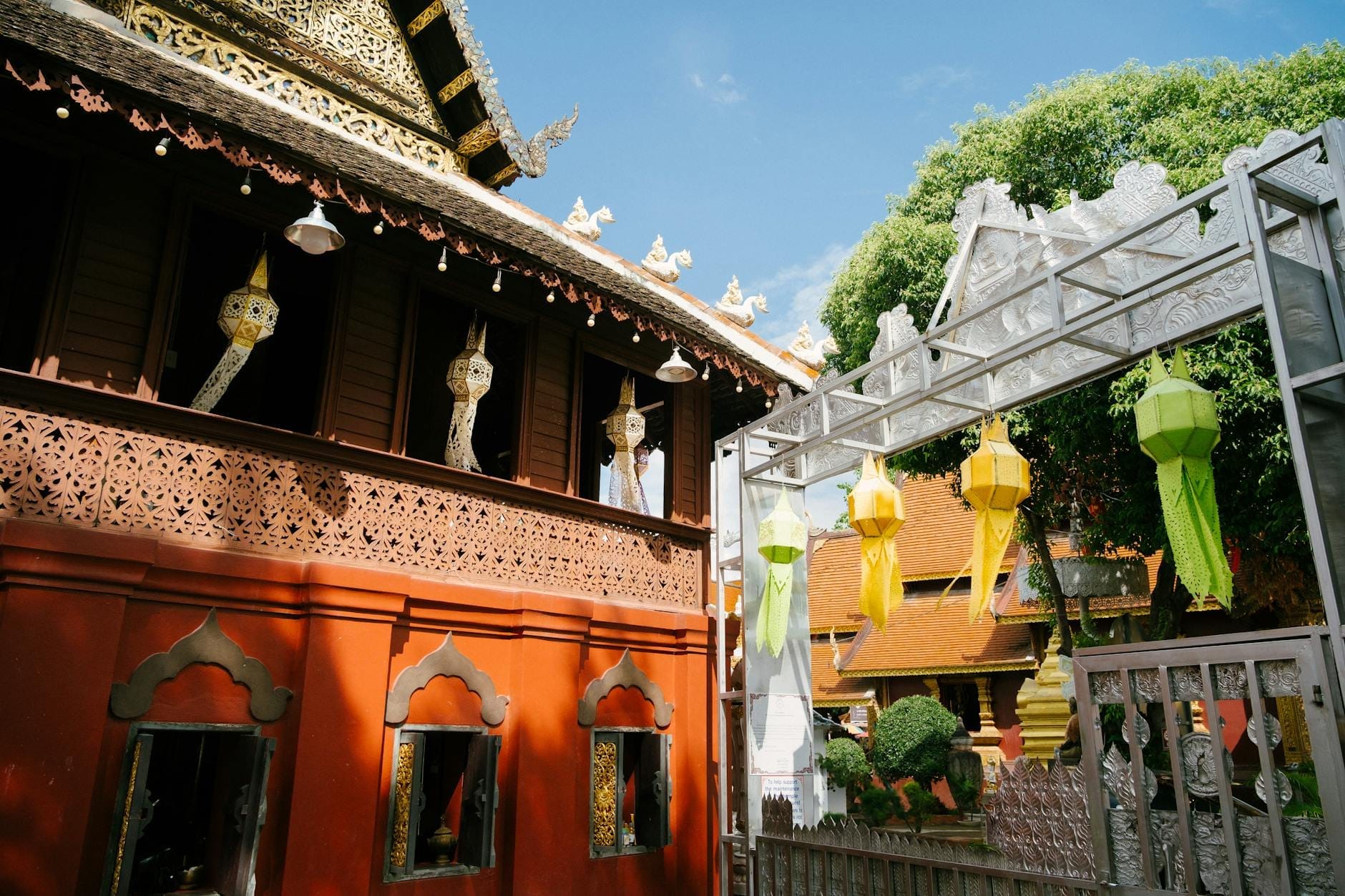 Tòa nhà gỗ với đèn lồng truyền thống và đèn lồng giấy đầy màu sắc treo bên ngoài, gợi lên không gian sáng tạo hoặc văn hóa ở Chiang Mai.