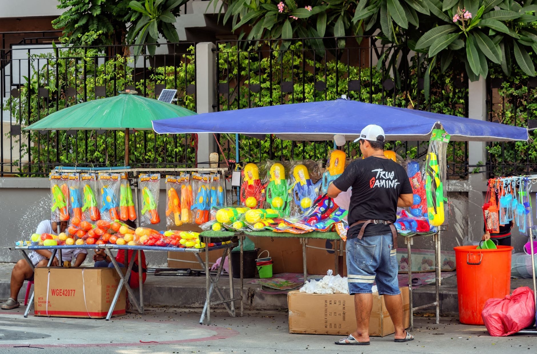 Các quầy súng nước Songkran đầy màu sắc được dựng trên một con phố ở Chiang Mai, trưng bày xô nước, súng phun nước và sự chuẩn bị cho lễ hội vào ban ngày.