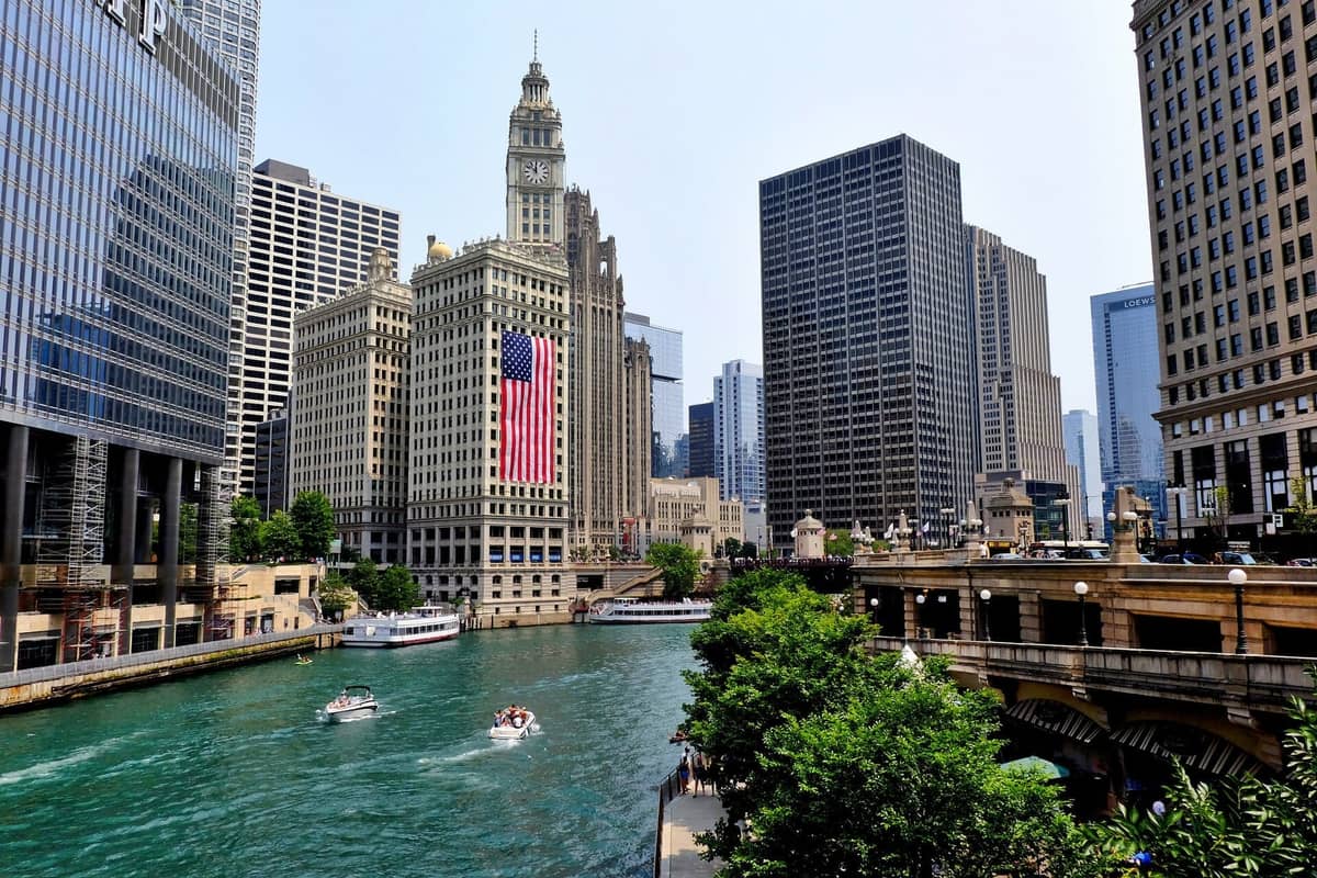 El río Chicago fluye junto a los rascacielos del centro, incluido el Wrigley Building con una gran bandera estadounidense exhibida para las celebraciones del 4 de julio.