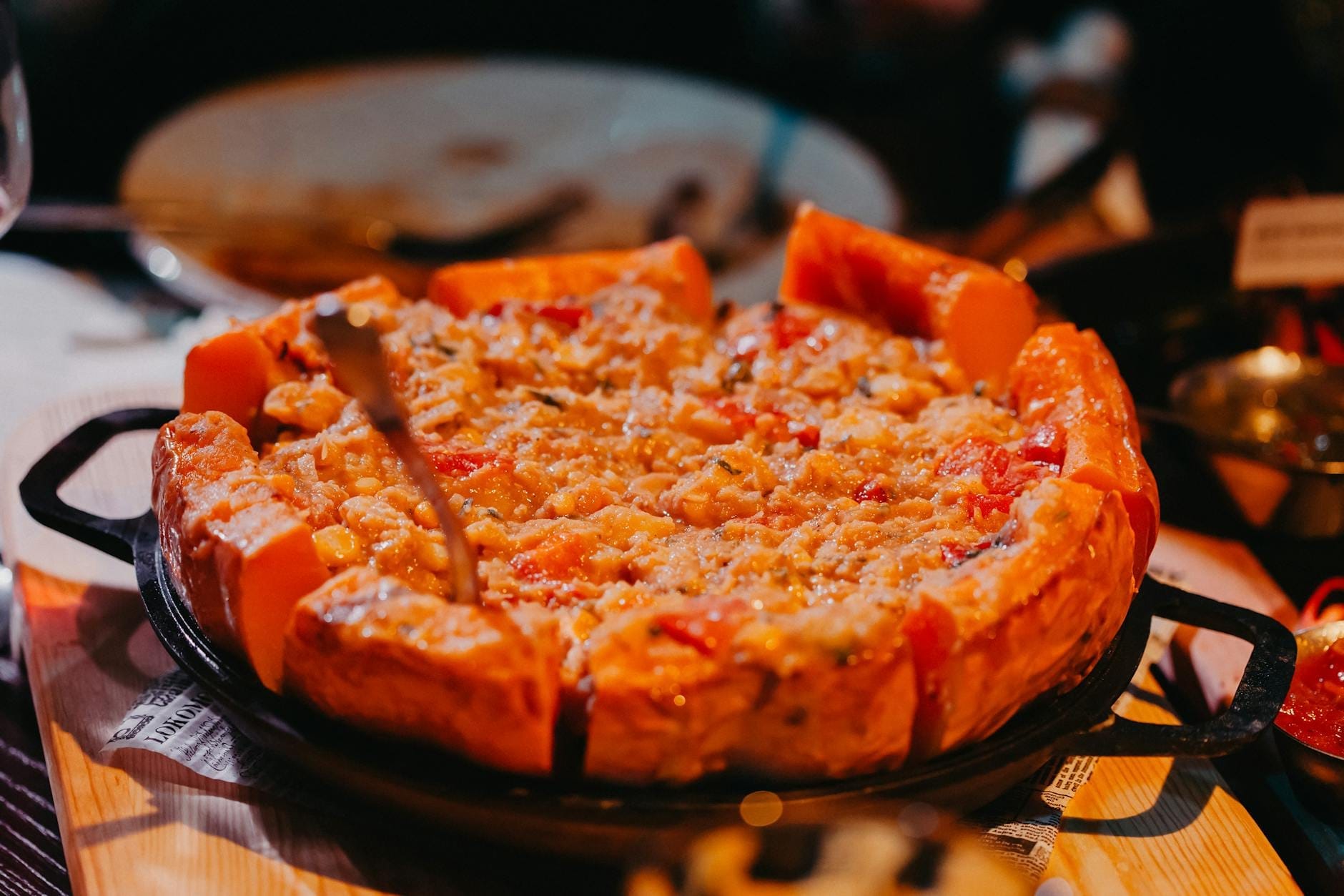 Uma pizza Chicago deep-dish fresquinha com massa dourada e cobertura de queijo sobre uma frigideira de ferro fundido em um acolhedor restaurante.