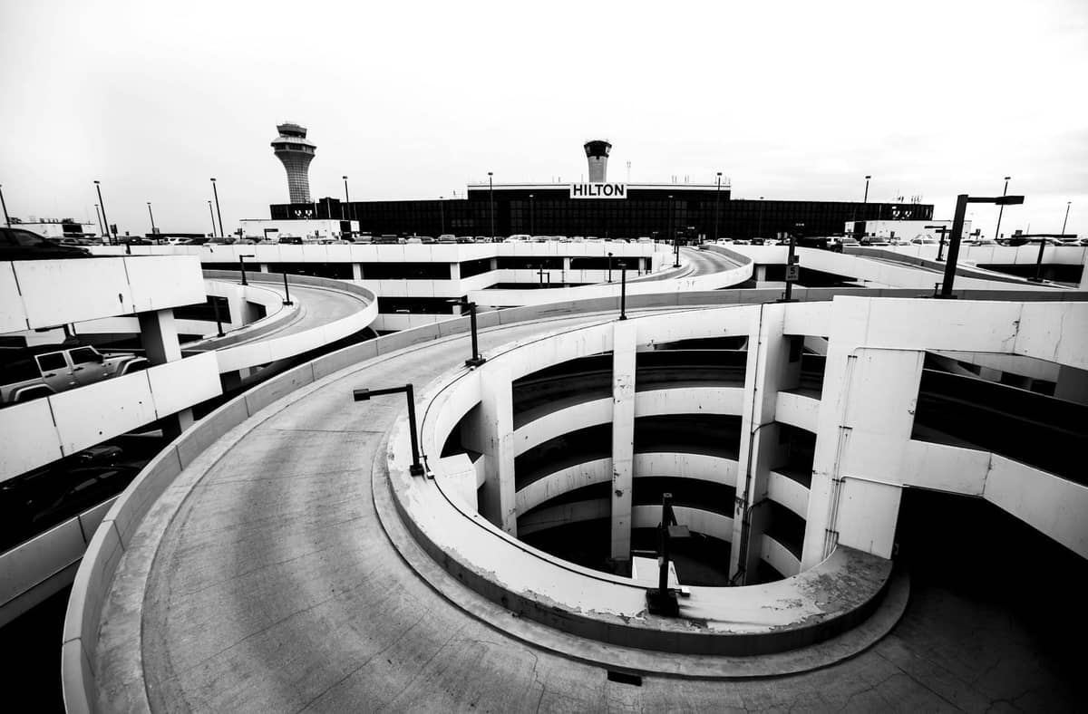Schwarz-Weiß-Ansicht des O'Hare International Airport mit geschwungener Parkstruktur und sichtbaren Kontrolltürmen.