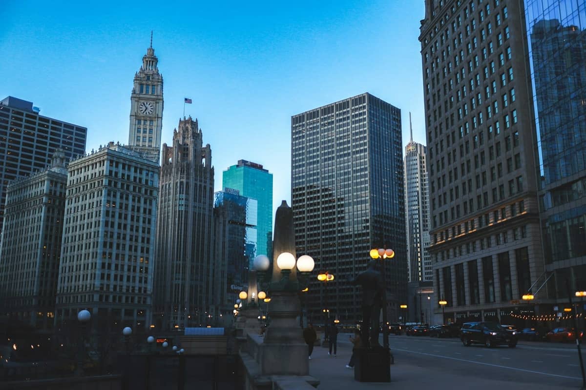 Iconici grattacieli di Chicago lungo Michigan Avenue al crepuscolo, con storici palazzi e lampioni vicino al Chicago River.