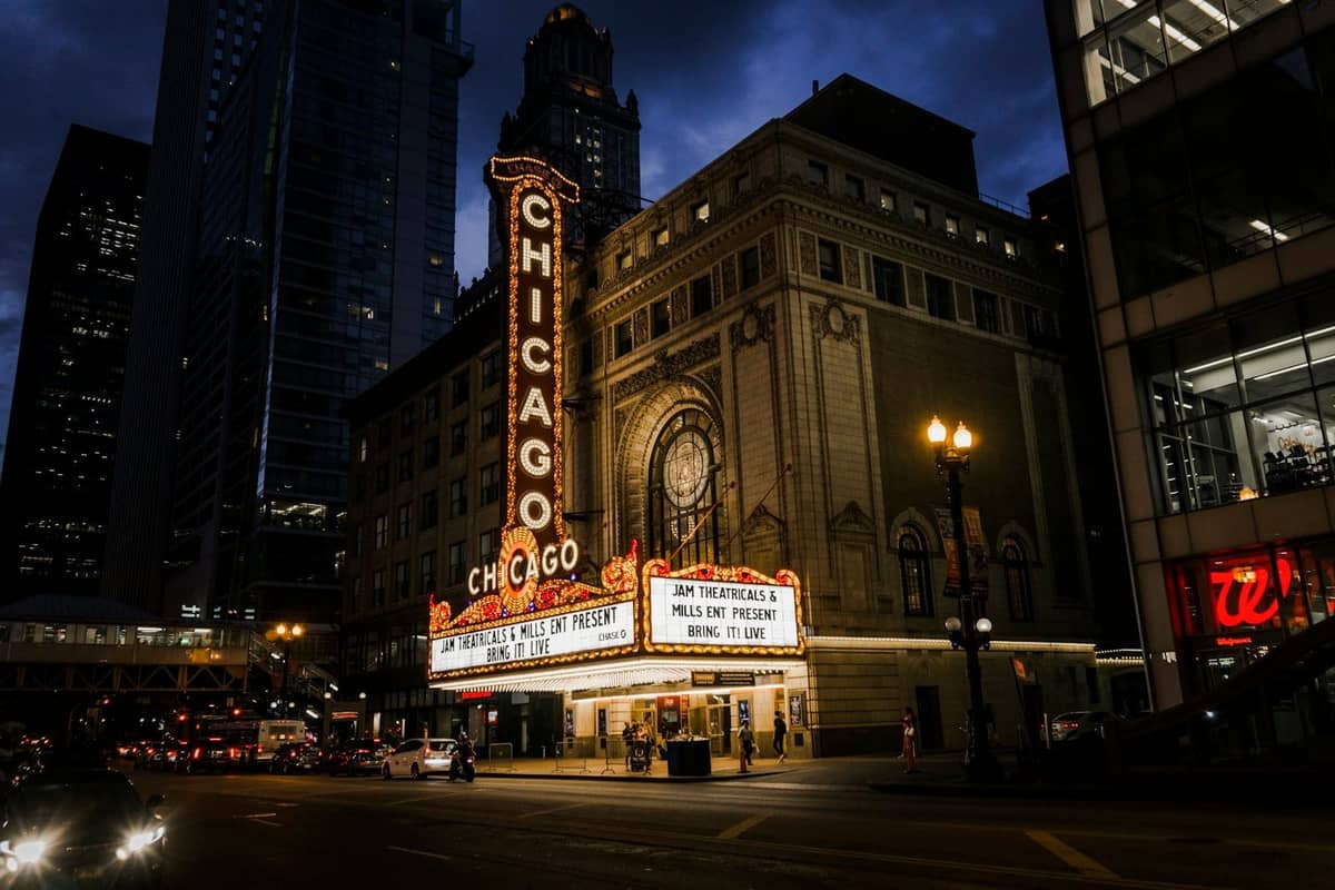 Il Chicago Theatre di notte con l'iconico insegna al neon e una vivace scena di strada, che cattura l'atmosfera vibrante della vita notturna del centro di Chicago.