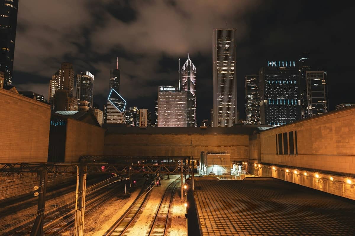 Vista notturna dei grattacieli di Chicago da una terrazza sul tetto, con le luci della città che brillano e nuvole spettacolari sopra.