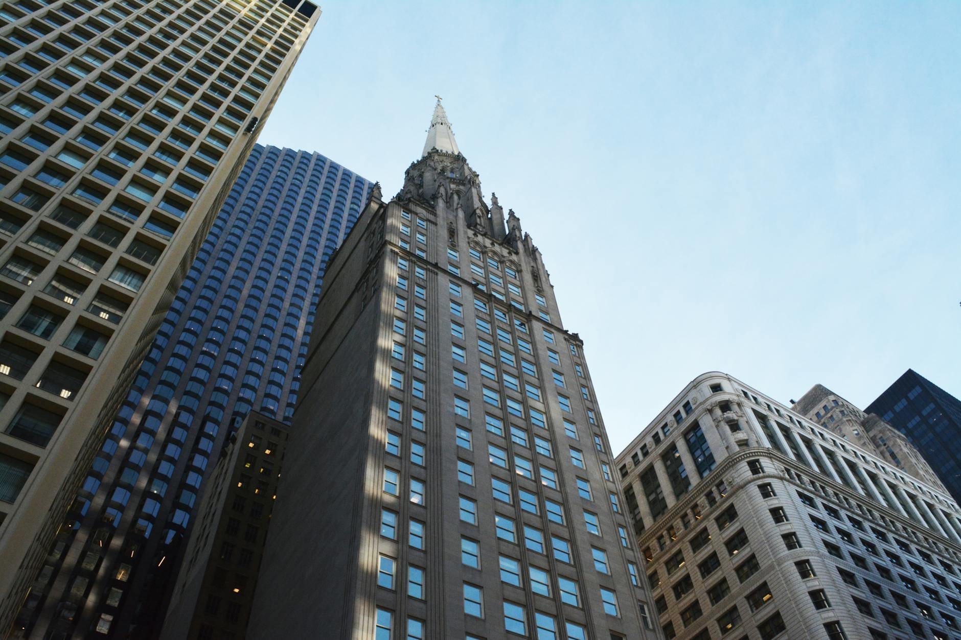 Il Chicago Temple Building con la sua caratteristica guglia gotica che si innalza sopra un grattacielo del centro, circondato dagli altri edifici alti del distretto del Loop.