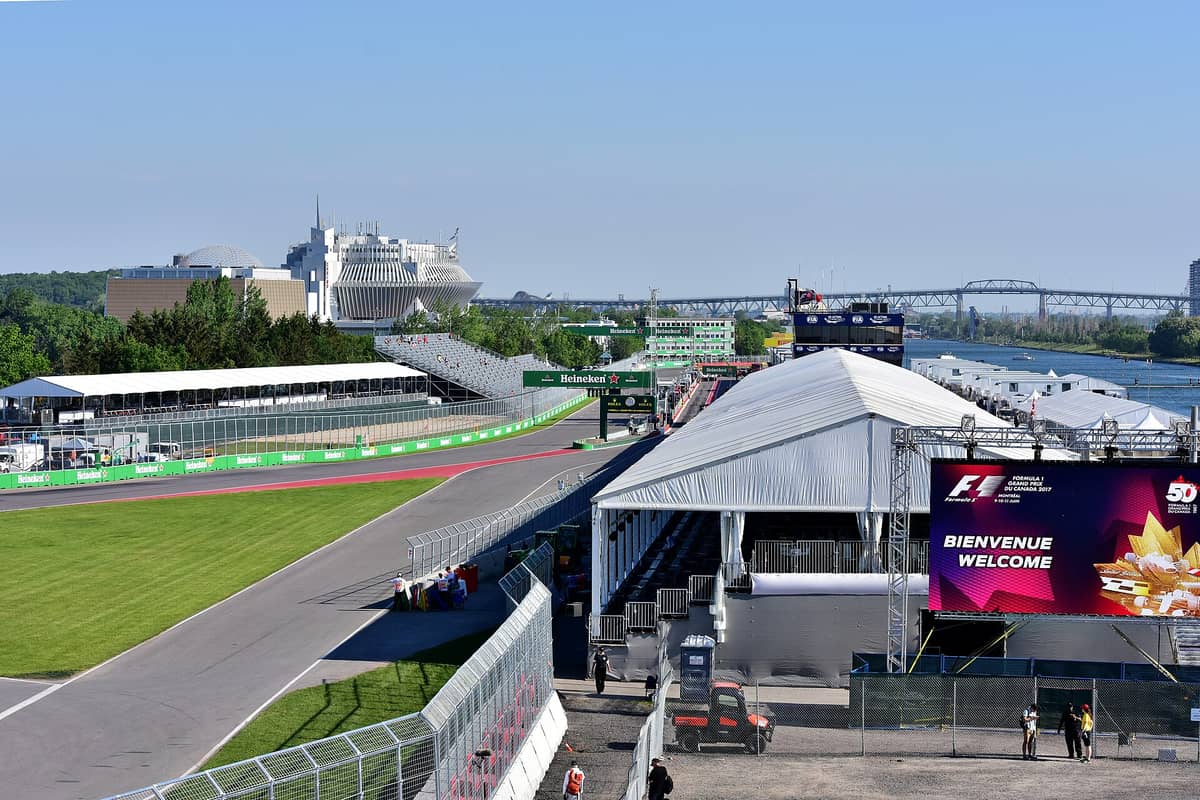 Weitwinkelansicht des Circuit Gilles-Villeneuve beim Großen Preis von Kanada, mit Rennstrecke, Boxengasse, Tribünen und der Skyline Montreals auf der Île Notre-Dame.
