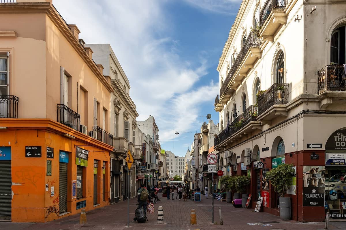 ถนนคนเดินใน Ciudad Vieja เมืองมอนเตวิเดโอ ที่เรียงรายไปด้วยอาคารประวัติศาสตร์ ร้านค้า และระเบียง ภายใต้ท้องฟ้าสีฟ้าสดใสพร้อมเมฆกระจัดกระจาย