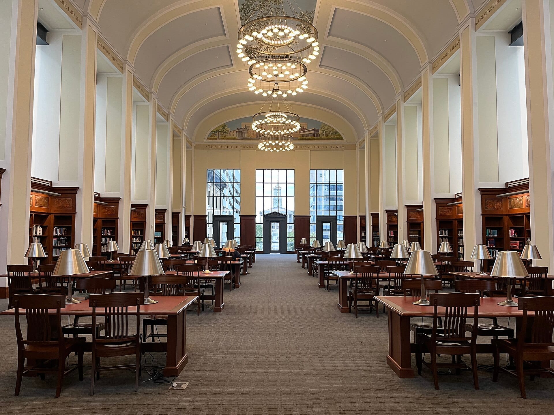 Vista amplia de la Sala de Derechos Civiles en Nashville Public Library, con altos techos arqueados, mesas de madera y lámparas de lectura.