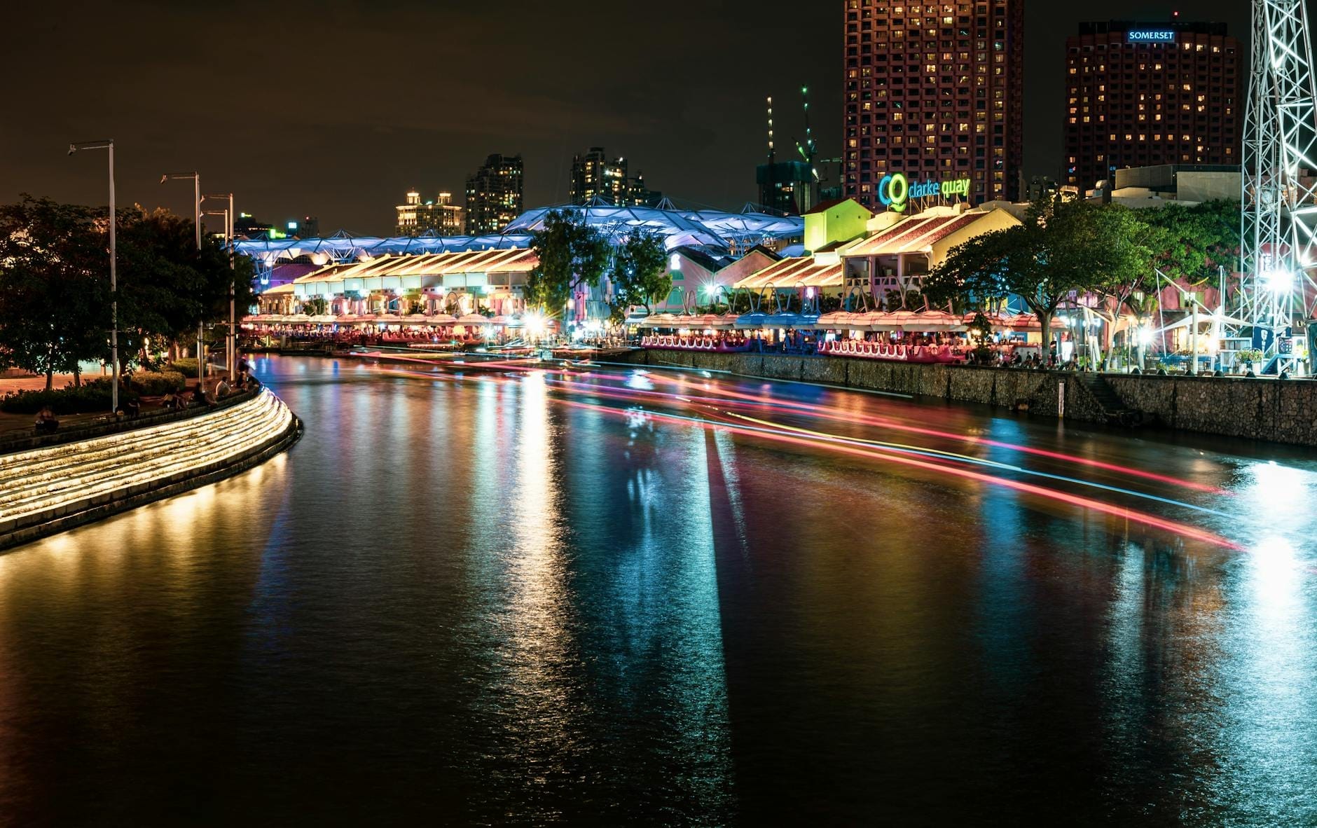 วิวคลาร์กคีย์ยามค่ำคืน แสงสีสันสะท้อนบนแม่น้ำสิงคโปร์ ตึกแถวริมน้ำสุดคึกคัก และบรรยากาศไนท์ไลฟ์ที่มีชีวิตชีวา