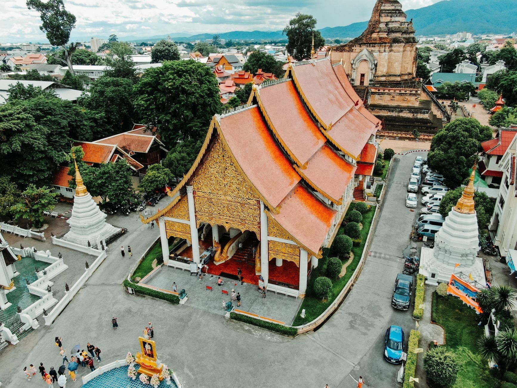Vista aérea de la Ciudad Antigua de Chiang Mai con edificios de templos históricos, vegetación y paisaje urbano, que ilustra un barrio conocido por sus mejores escuelas de cocina.