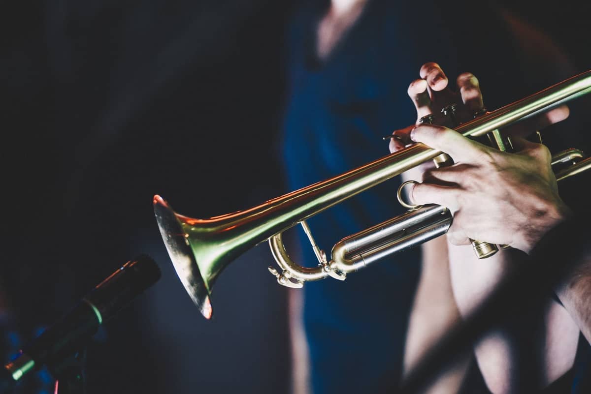 Nahaufnahme der Hände eines Musikers, der auf der Bühne unter buntem Licht beim Copenhagen Jazz Festival Trompete spielt.