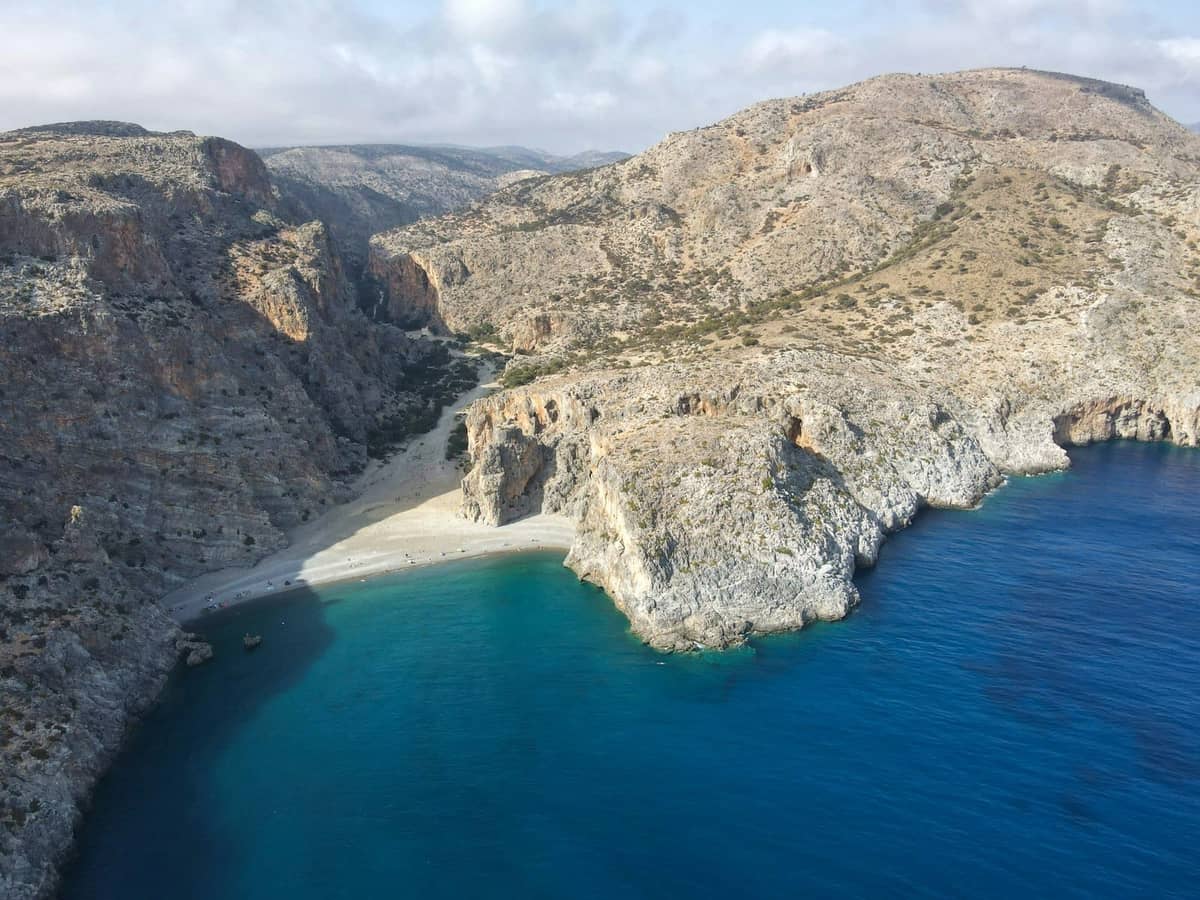 Una spiaggia isolata con acque turchesi incastonata tra spettacolari scogliere rocciose sulla costa orientale di Creta.
