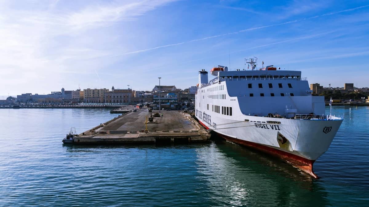 Duży prom zacumowany w porcie Heraklion na Krecie w pogodny dzień, z budynkami miasta widocznymi w tle