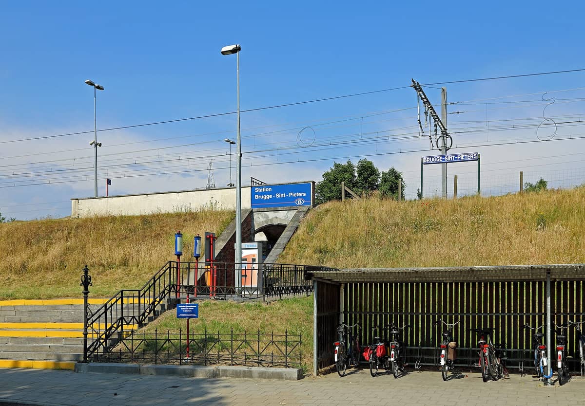 Bike parking shelter with several bicycles and a visible Station Brugge-Sint-Pieters sign in Bruges, Belgium
