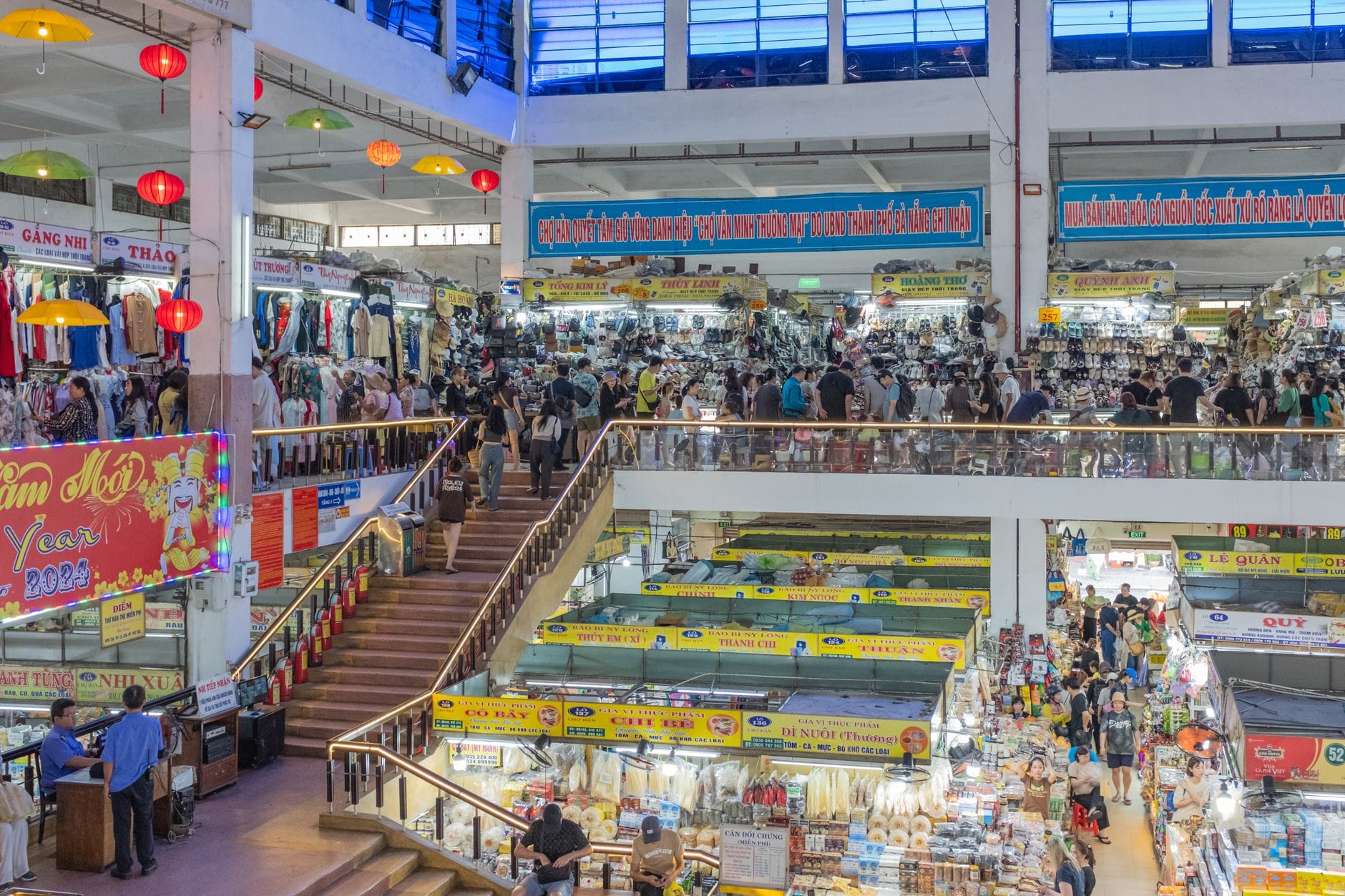 บรรยากาศในตลาดฮาน ดานัง มีร้านค้าขายเสื้อผ้าและของฝากมากมาย ผู้คนเดินช้อปปิ้งทั้งสองชั้น