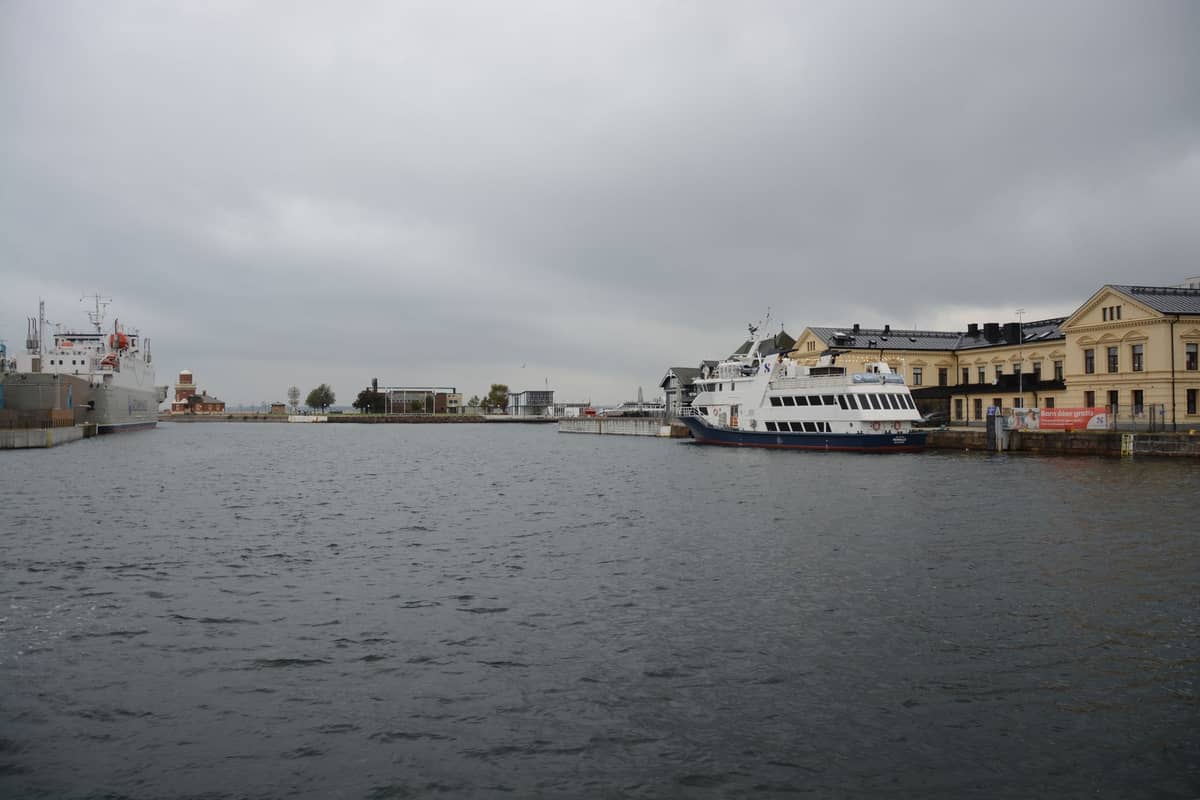 View across Port Adelaide's harbor with docked boats and historic warehouses under cloudy sky.