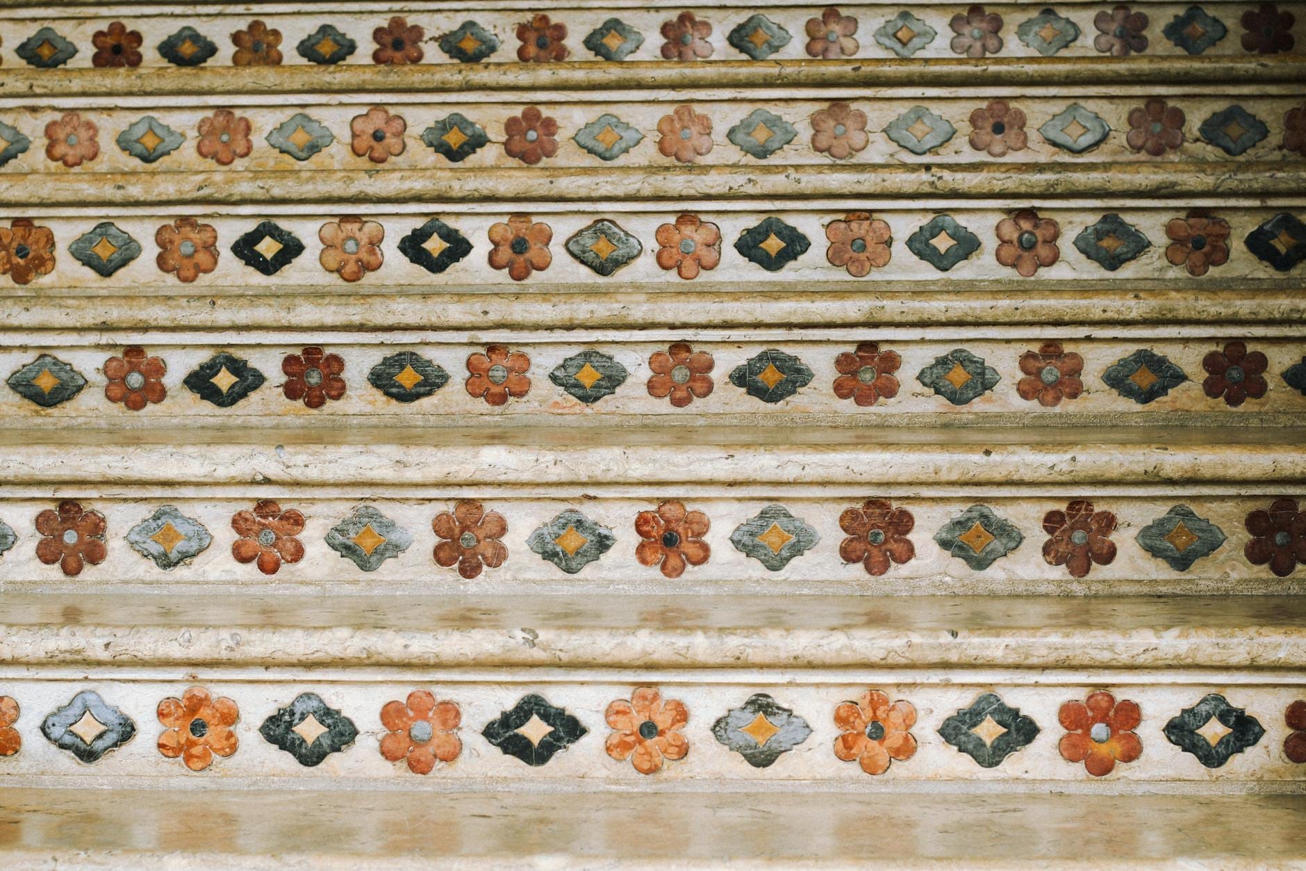 Nahaufnahme von keramikgefliesten Stufen, verziert mit bunten Blumenmustern, die an die berühmte Treppe in Caltagirone, Sizilien, erinnern.