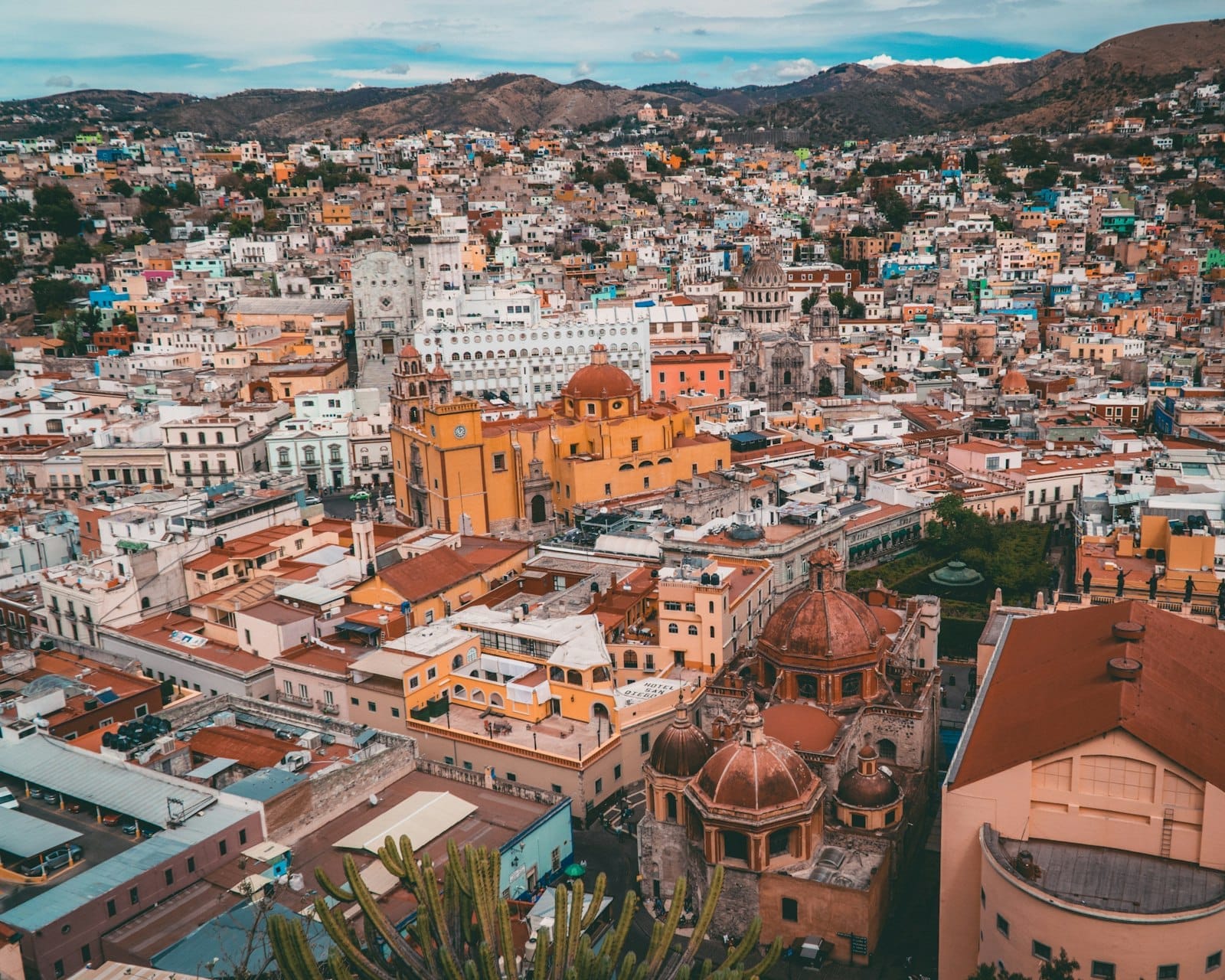 Vista ampla da colorida cidade colonial de Guanajuato com morros ao fundo, mostrando um destino vibrante e popular para passeios de um dia a partir da Cidade do México.