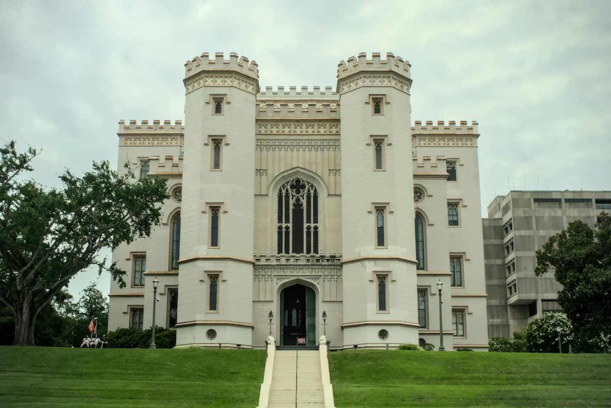 Front view of the Old State Capitol building in Baton Rouge with Gothic towers and manicured lawn.