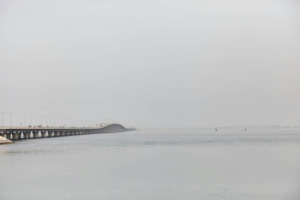 Long overwater bridge stretching across Lake Pontchartrain with calm water and hazy sky