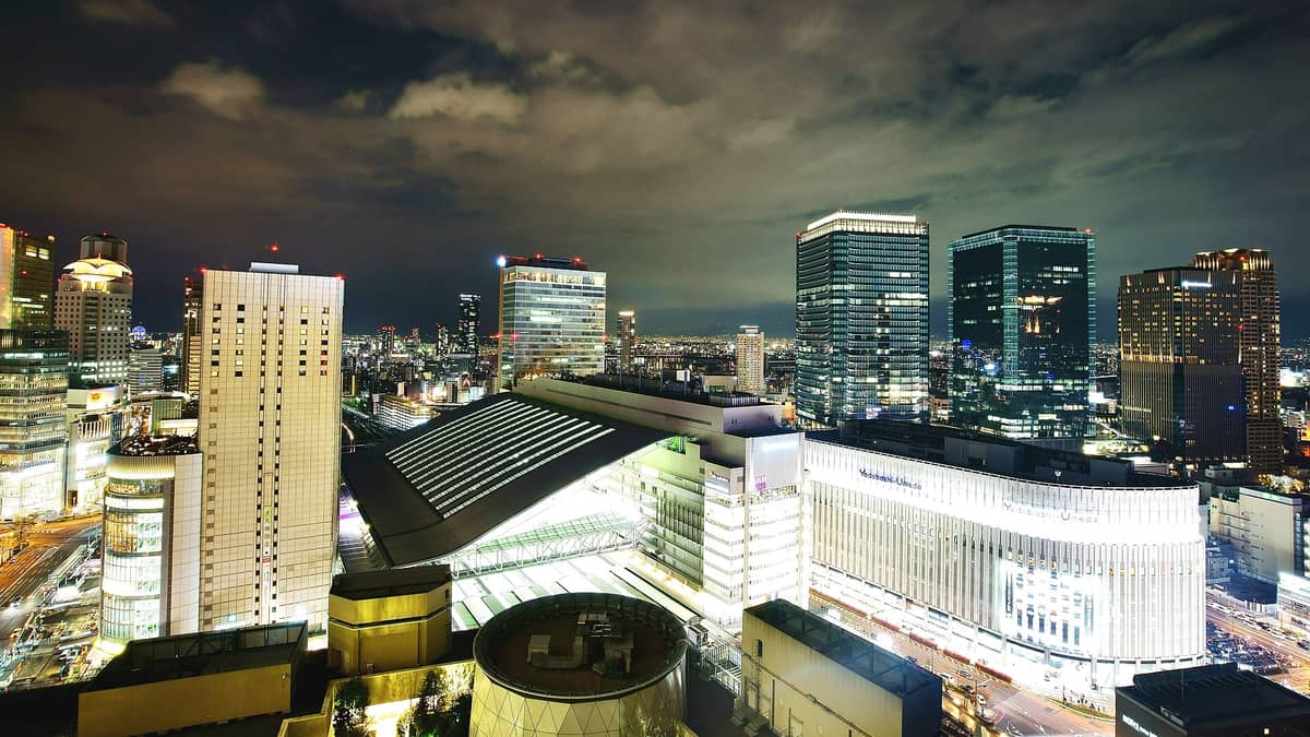 A sweeping nighttime view of Osaka Station and surrounding skyscrapers, showcasing the central urban hub and transport links in Osaka.