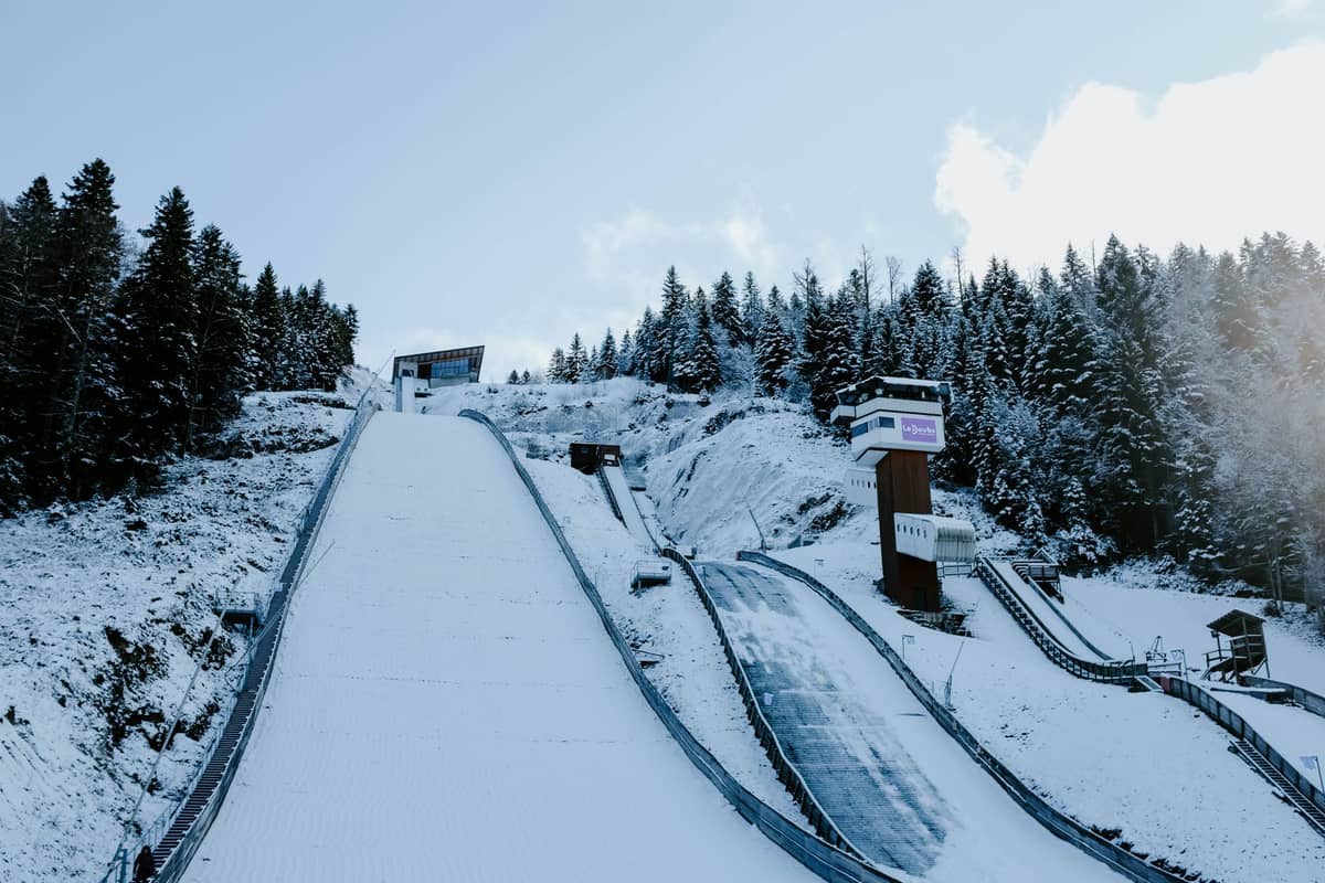 สกีจั๊มพ์และหอคอย Holmenkollen ที่ปกคลุมด้วยหิมะ ล้อมรอบด้วยป่าภายใต้ท้องฟ้าฤดูหนาวที่สดใส