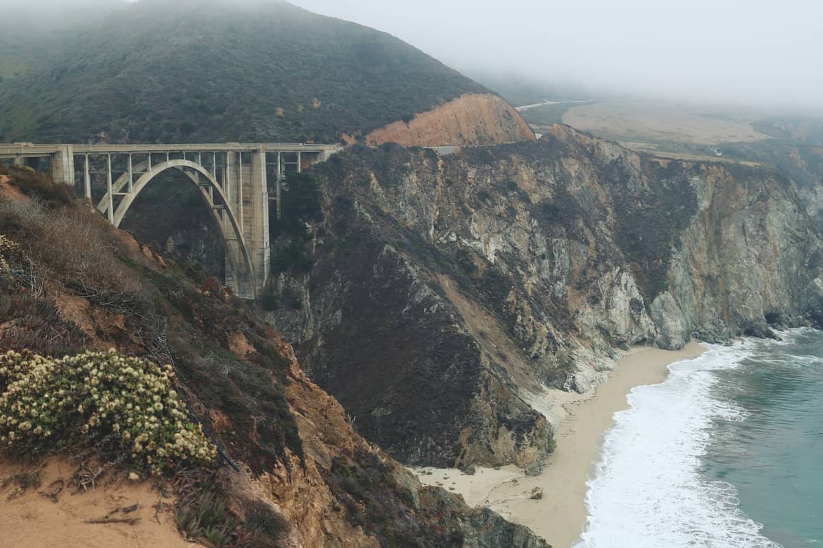 Il Bixby Creek Bridge che attraversa scogliere spettacolari sopra la Highway 1 e l'oceano Pacifico in una giornata nebbiosa