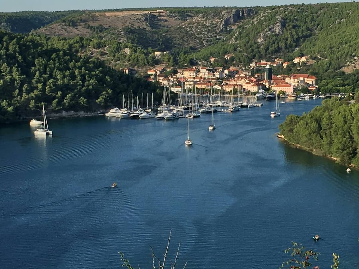Vista di Skradin con le barche del porticciolo, il fiume e le colline circostanti, che mostra la posizione della città sul fiume vicino al Parco Nazionale della Krka.