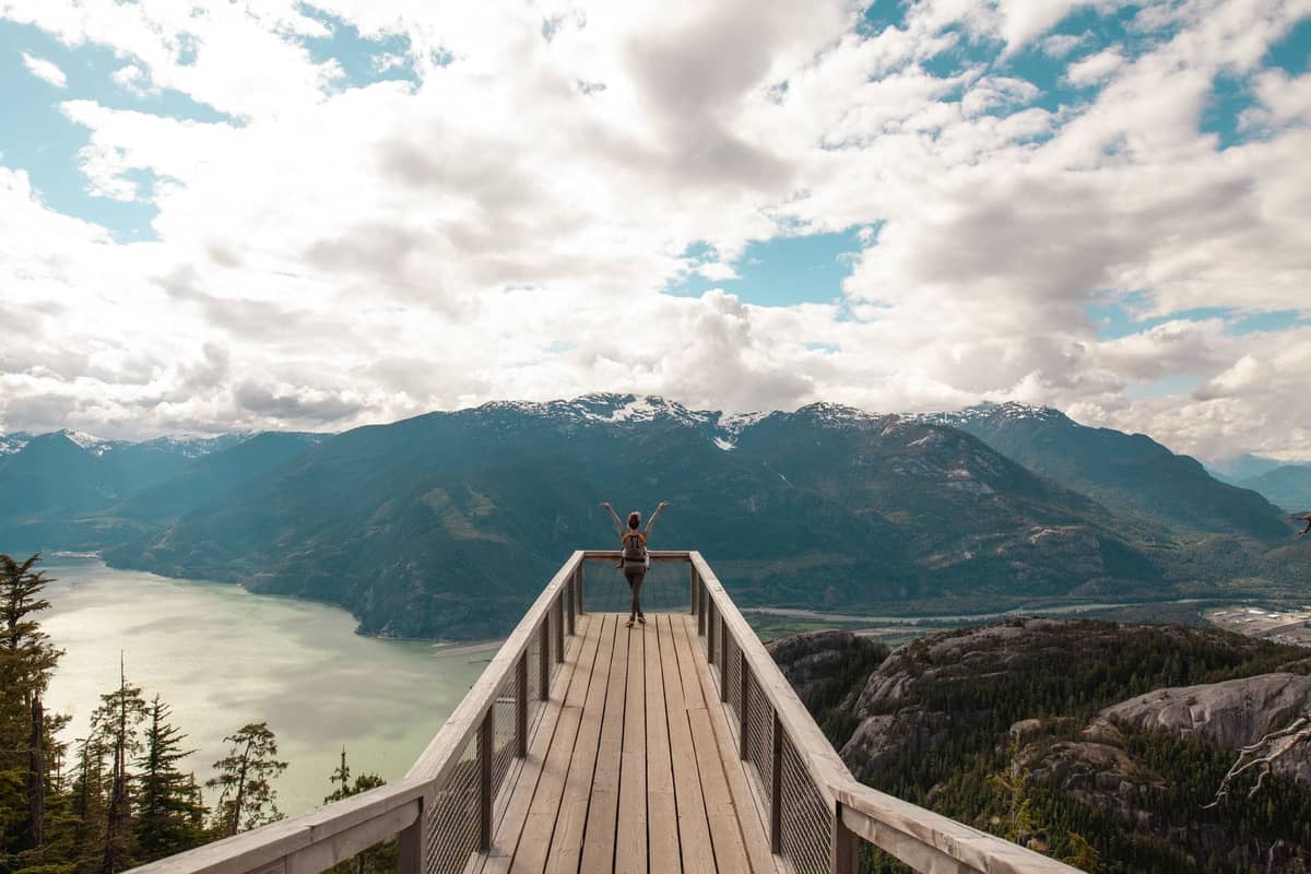 Person auf der Aussichtsplattform mit Blick auf den Howe Sound und die Berge am Sea-to-Sky Highway in der Nähe von Squamish.