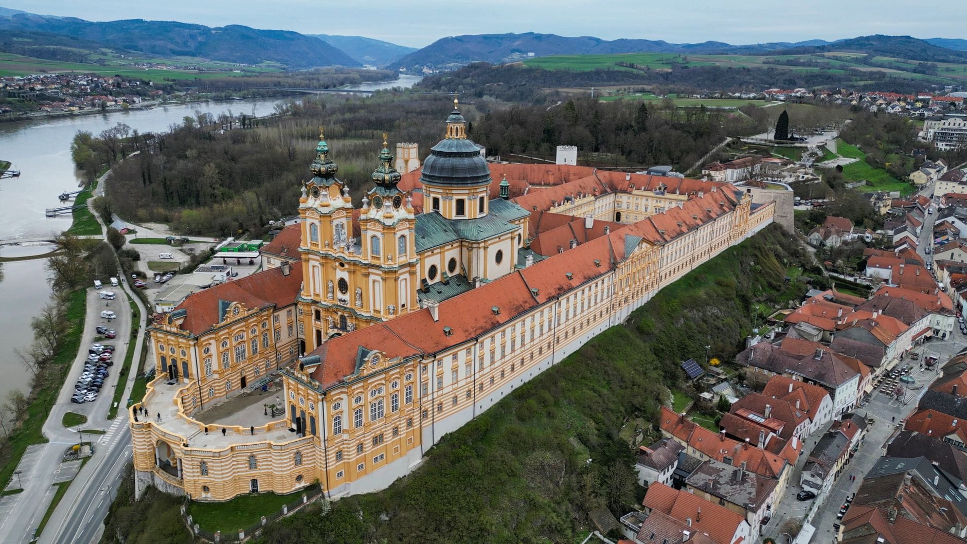 Vista aérea de la Abadía de Melk y el paisaje circundante del Valle de Wachau con el río Danubio y pintorescos colinas al fondo.