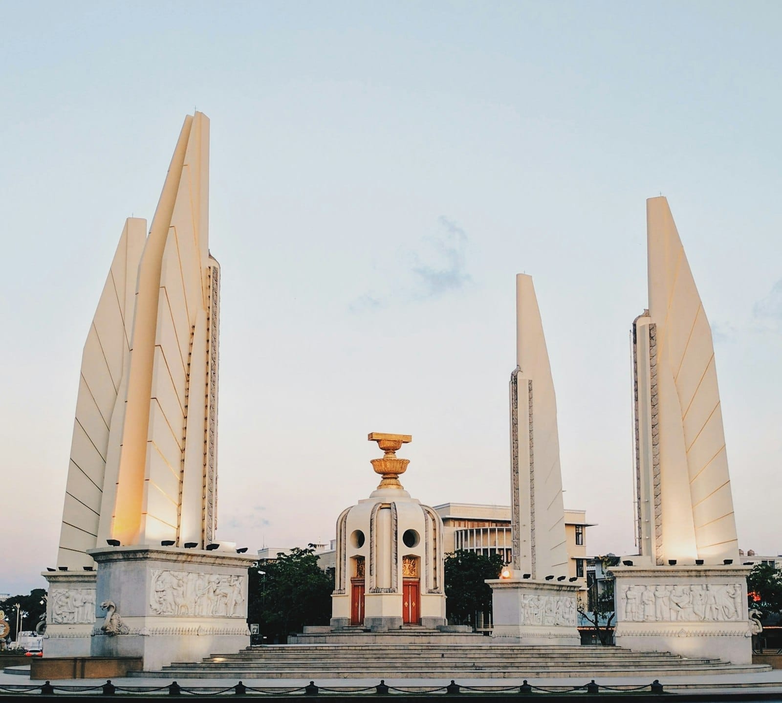 L'imponente Monumento alla Democrazia di Bangkok con le quattro colonne alate e il piedistallo centrale della costituzione, al centro di una trafficata rotatoria.