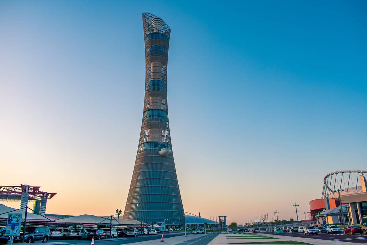 Landschaftsansicht des Aspire Tower in der Aspire Zone, mit Parkplatz und der Struktur des Khalifa Stadium rechts in Doha sichtbar.