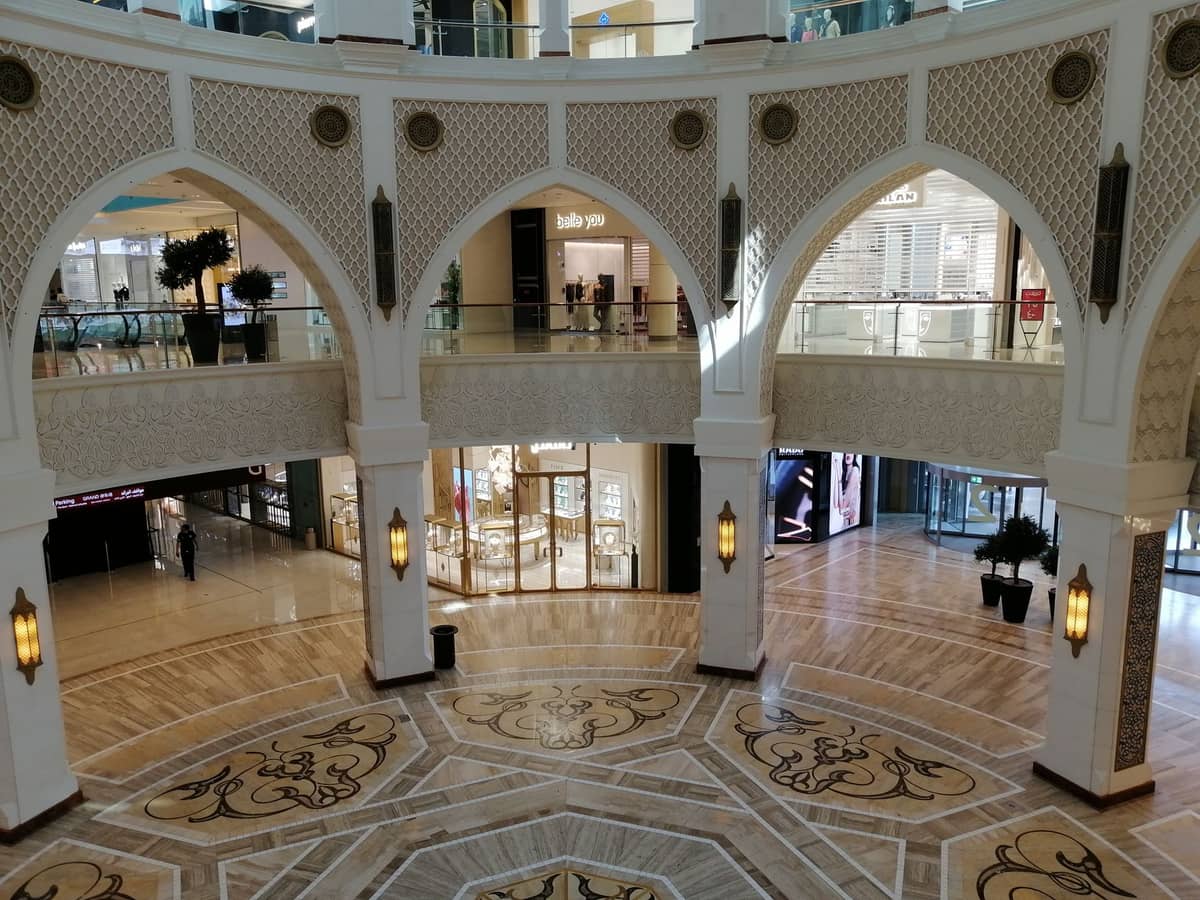 Innenbereich des Dubai Gold Souk im Ibn Battuta Mall mit verzierten Bögen, goldener Dekoration und Schmuckgeschäften auf beiden Etagen.