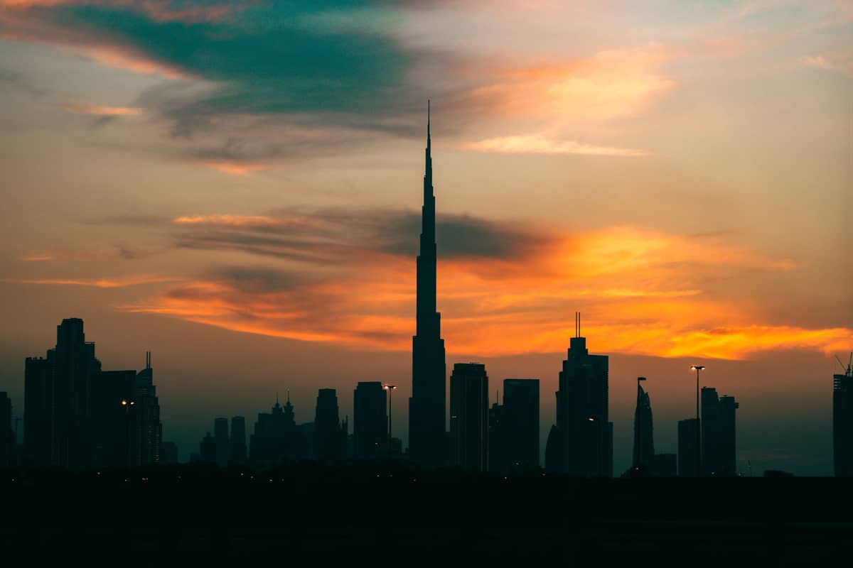 Skyline von Dubai bei Sonnenuntergang mit dem Burj Khalifa im Mittelpunkt und bunten Wolken am Himmel