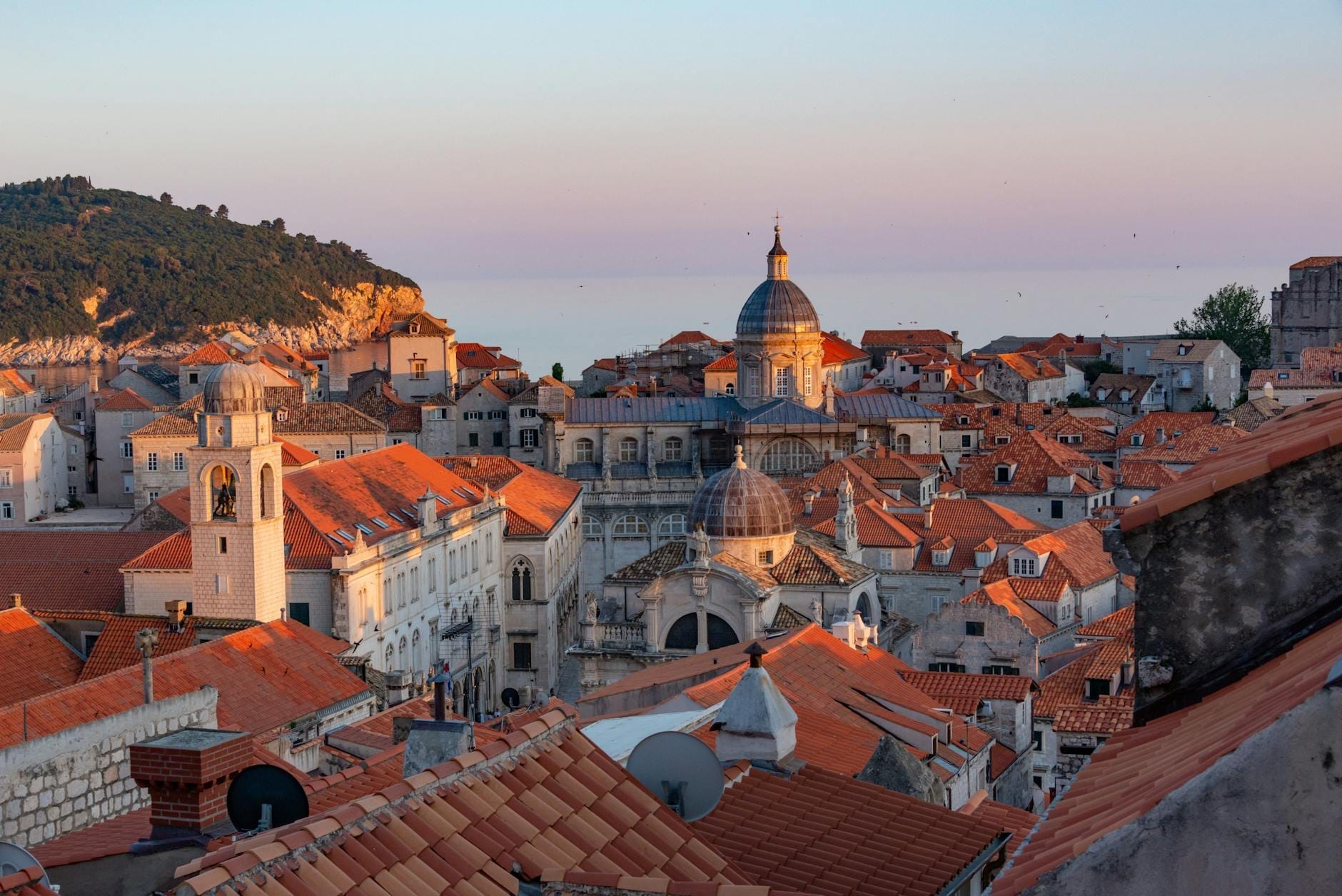 Vista desde las azoteas del casco antiguo de Dubrovnik al atardecer con la iglesia de San Blas y los edificios históricos circundantes claramente visibles.