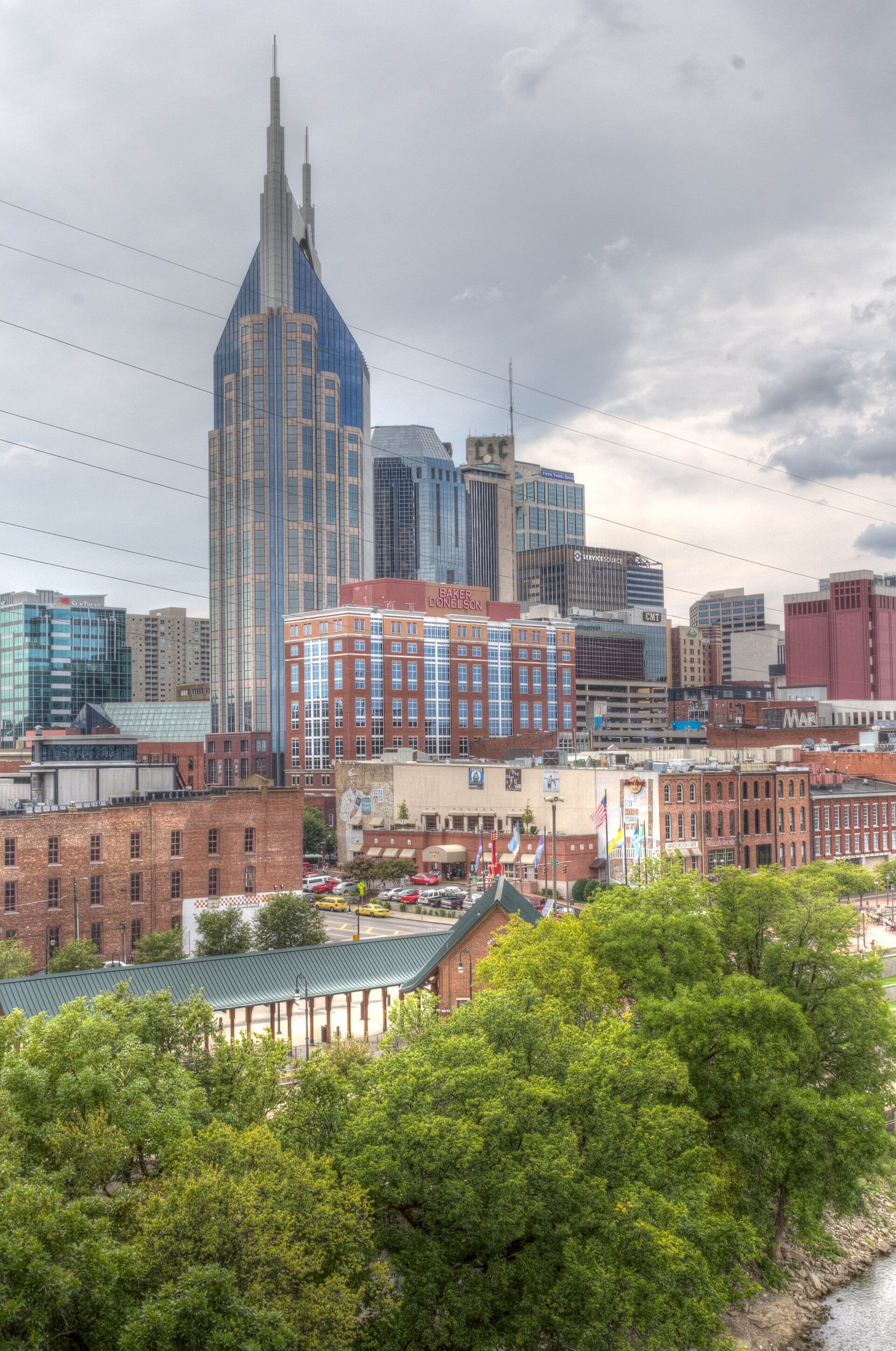 Horizonte del centro de Nashville visto desde East Nashville, con el icónico AT&T Building, históricos edificios de ladrillo y frondosos árboles verdes en primer plano.