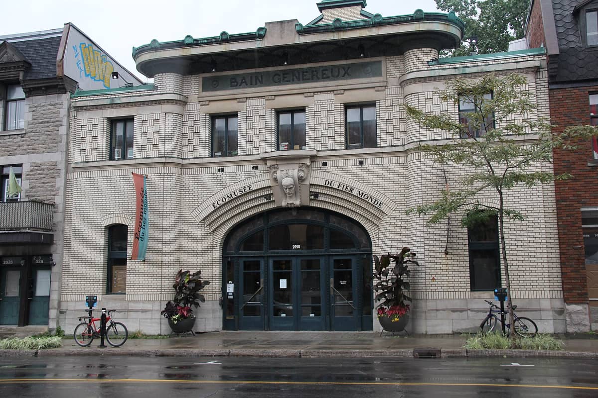Fassade des Écomusée du fier monde in Montreal, untergebracht im historischen Bain Généreux, mit dem charakteristischen Mauerwerk und dem gewölbten Eingang.