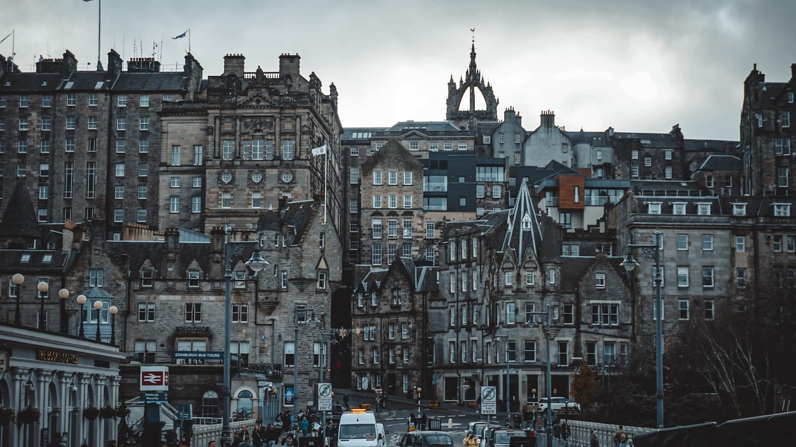 Edifici dell'Old Town di Edinburgh visti da una strada più bassa, con architettura storica in pietra e una guglia di chiesa visibile sotto cieli nuvolosi.