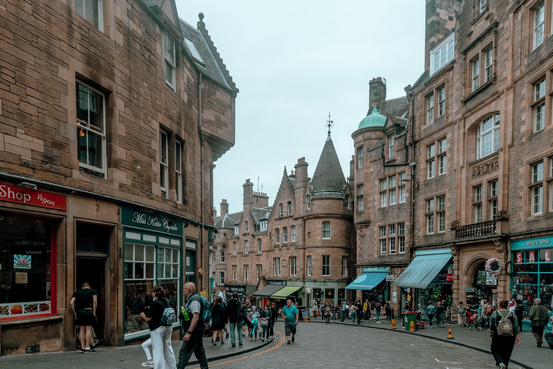 Die Victoria Street in Edinburghs Old Town mit ihrer geschwungenen Kopfsteinpflasterstraße und bunten Ladenfronten – ein reales Vorbild für Harry Potters Winkelgasse.