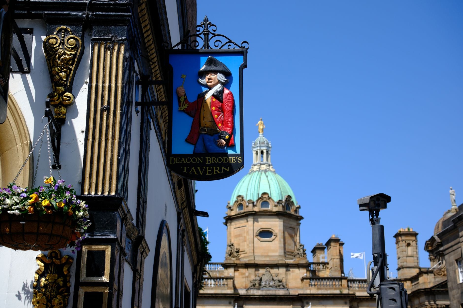 Straßenansicht des Deacon Brodie's Tavern mit dem markanten Pub-Schild und historischer Kuppel im Hintergrund – ein Klassiker des Edinburgher Nachtlebens in der Old Town.