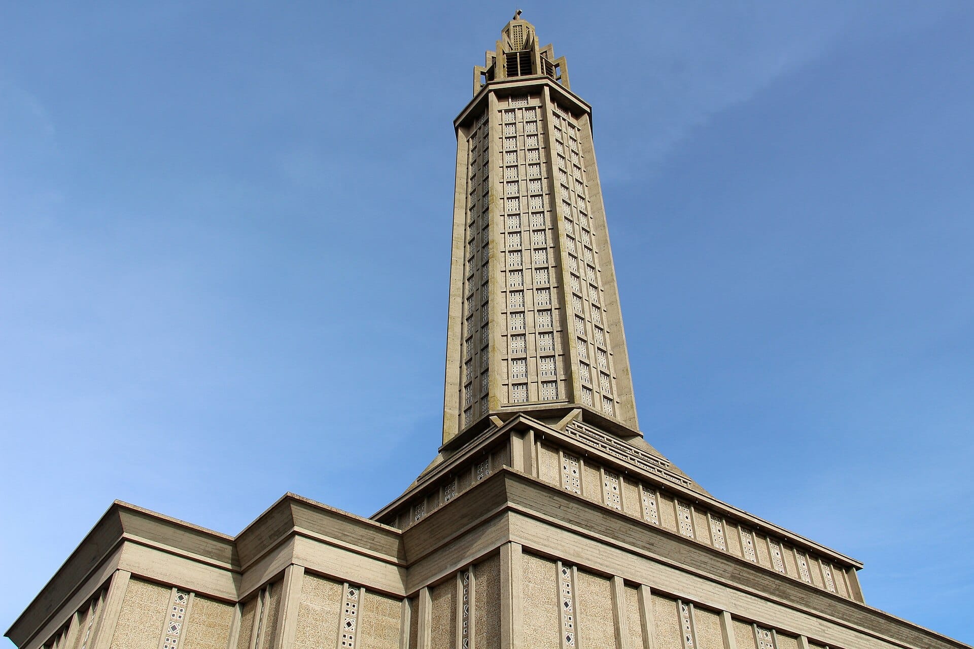 L'imponente guglia a lanterna dell'Église Saint-Joseph a Le Havre si innalza contro un cielo azzurro limpido, mettendo in mostra la moderna architettura in cemento.