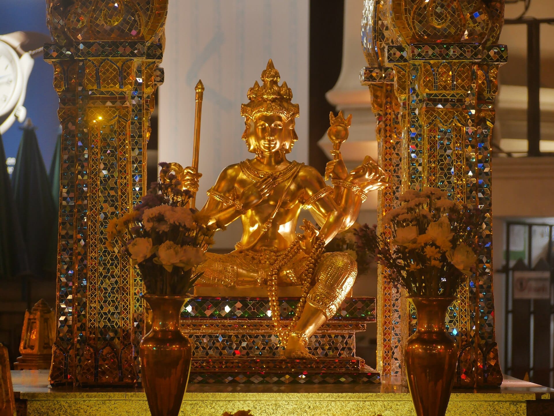 Santuario di Erawan a Bangkok con la statua dorata di Brahma e i pilastri decorativi del tempietto