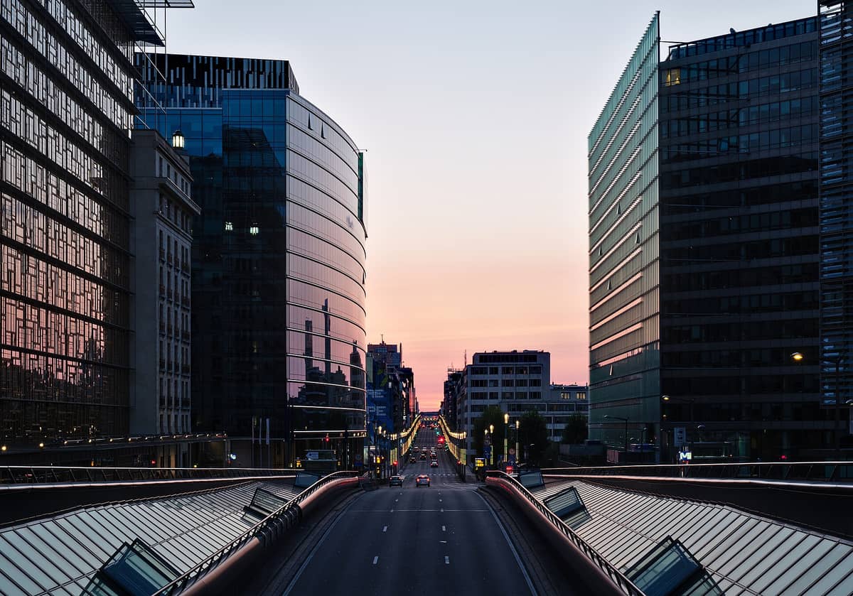 Vista dos modernos prédios de vidro e do boulevard principal ao pôr do sol no Bairro Europeu de Bruxelas, mostrando o coração do distrito da UE.