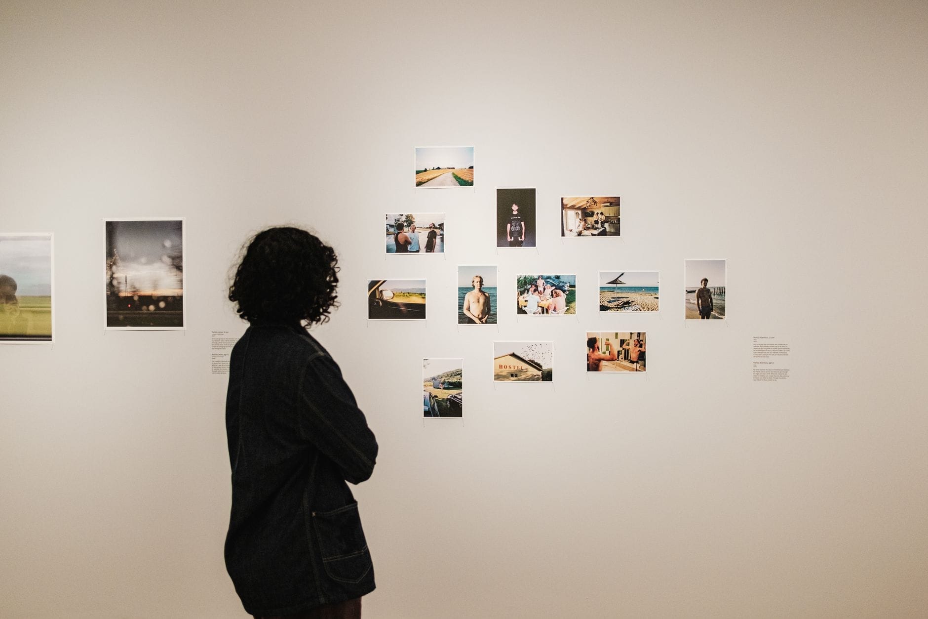 Un visitante estudia una pared blanca de galería con fotografías coloridas en el FOAM Photography Museum en una casa del canal Keizersgracht de Ámsterdam.